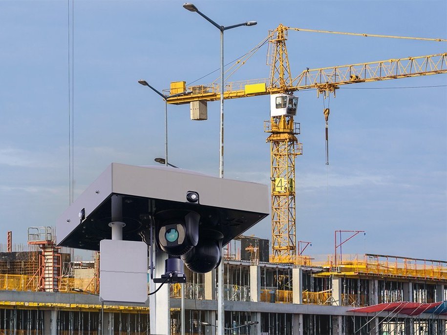 Dôme motorisé 360 degrés d'une tour de surveillance OMNIGARD, grues de chantier en arrière-plan